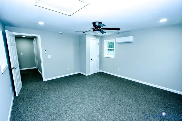 an empty room with a ceiling fan and a window