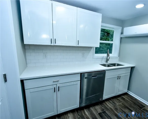 a kitchen with granite countertop white cabinets and sink