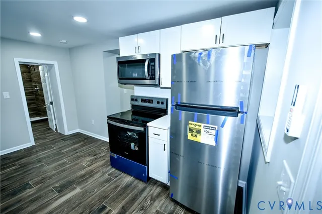 a kitchen with stainless steel appliances a refrigerator and a stove top oven