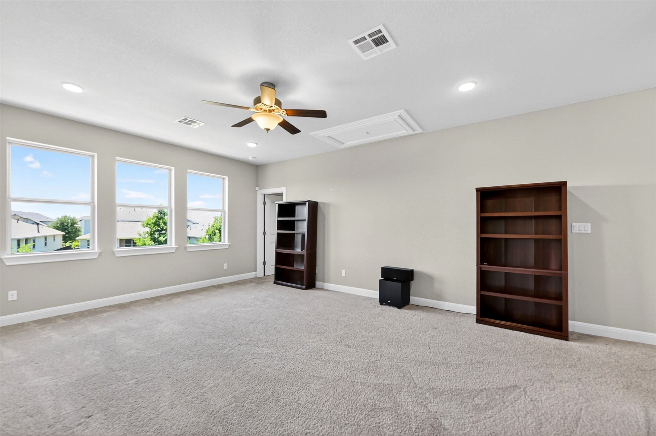 1201 Positano Pass Leander, TX 78641 - Photo 34 of 40 Spacious room with plush carpet flooring, three large windows, recessed lighting, and a ceiling fan