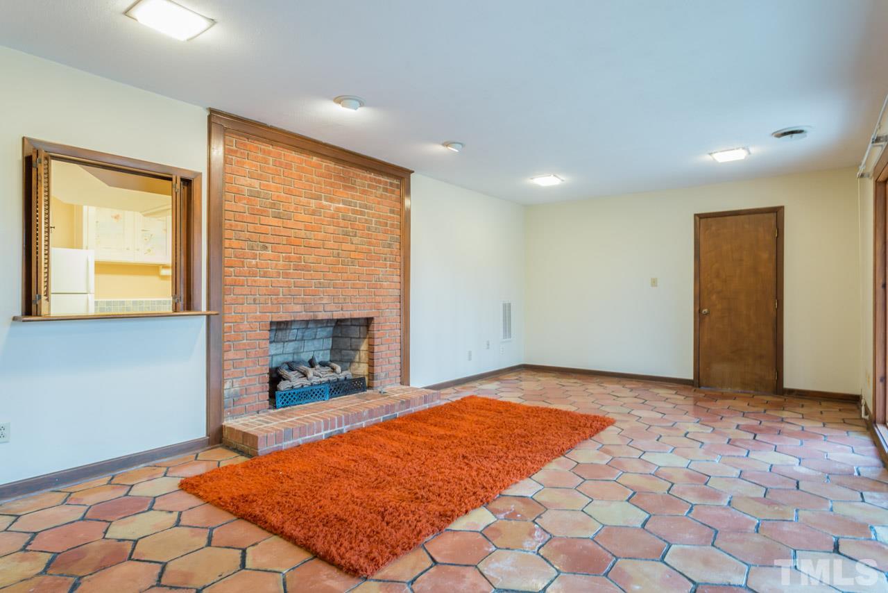 6701 Laurdane Road Raleigh, NC 27613 - Photo 16 of 24 a view of an empty room with a fireplace and a window