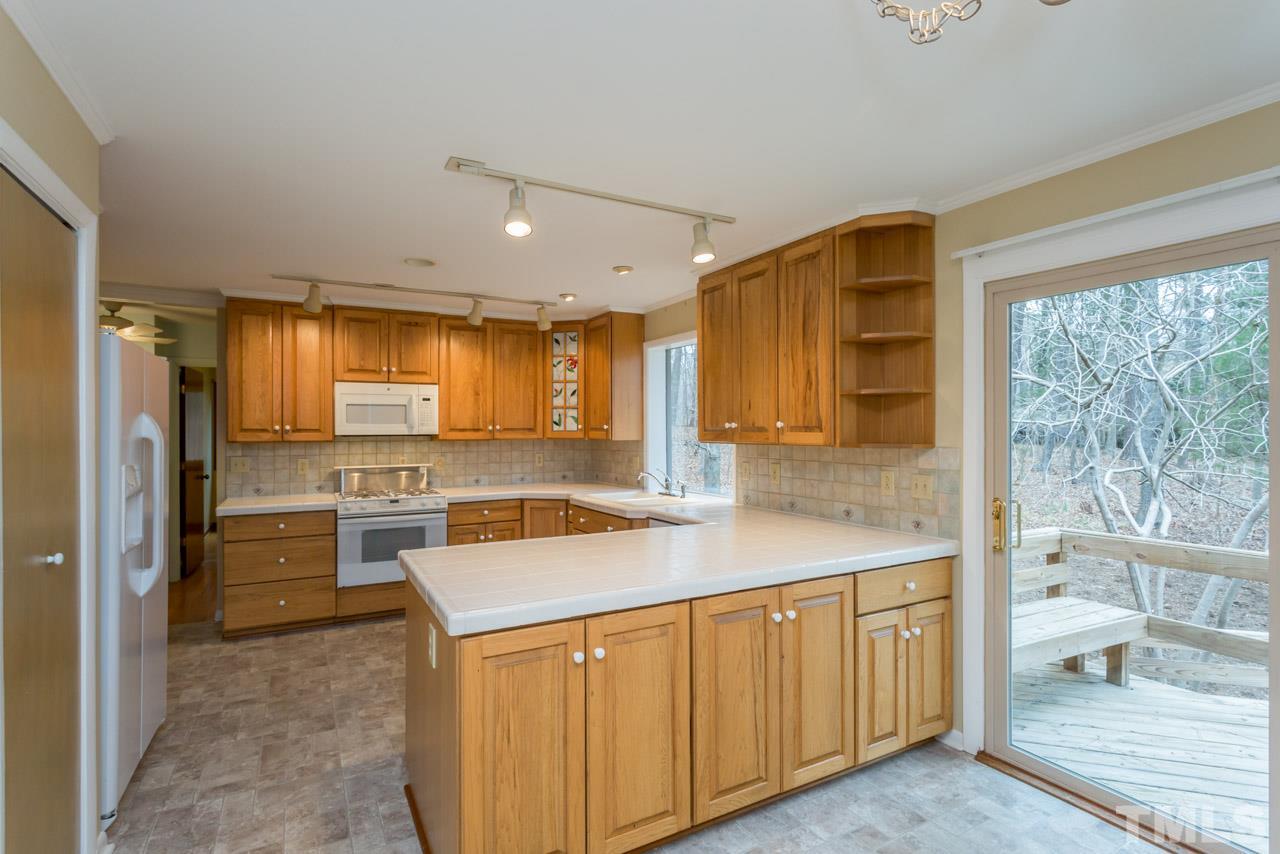 6701 Laurdane Road Raleigh, NC 27613 - Photo 4 of 24 a kitchen that has a lot of cabinets in it and wooden floors