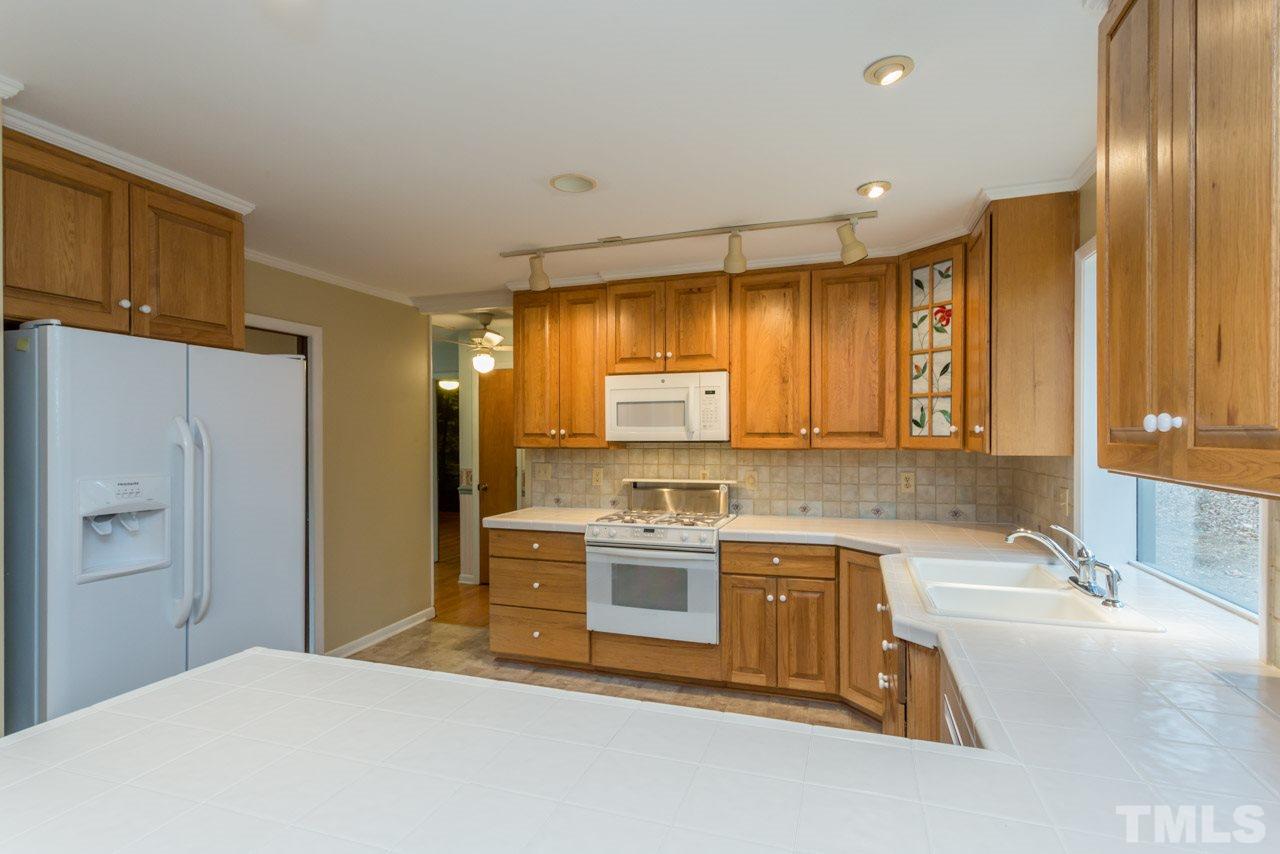 6701 Laurdane Road Raleigh, NC 27613 - Photo 6 of 24 a kitchen with a stove a sink and a refrigerator