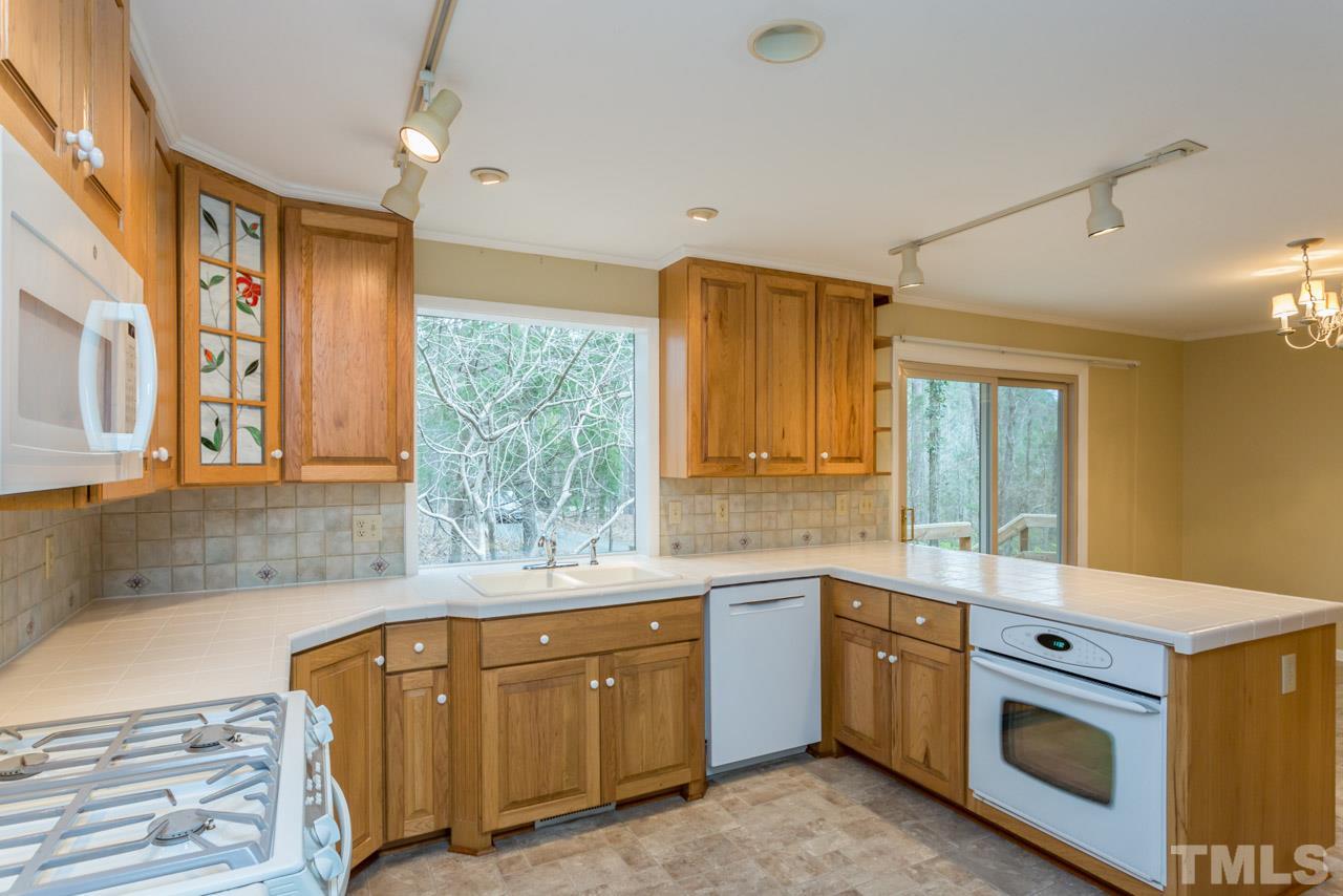 6701 Laurdane Road Raleigh, NC 27613 - Photo 7 of 24 a kitchen with sink a stove and cabinets