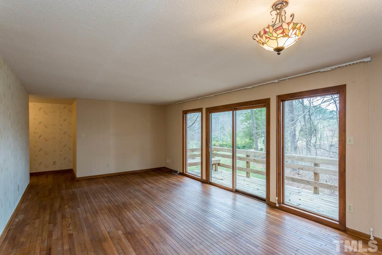6701 Laurdane Road Raleigh, NC 27613 - Photo 8 of 24 a view of a livingroom with wooden floor and a large window