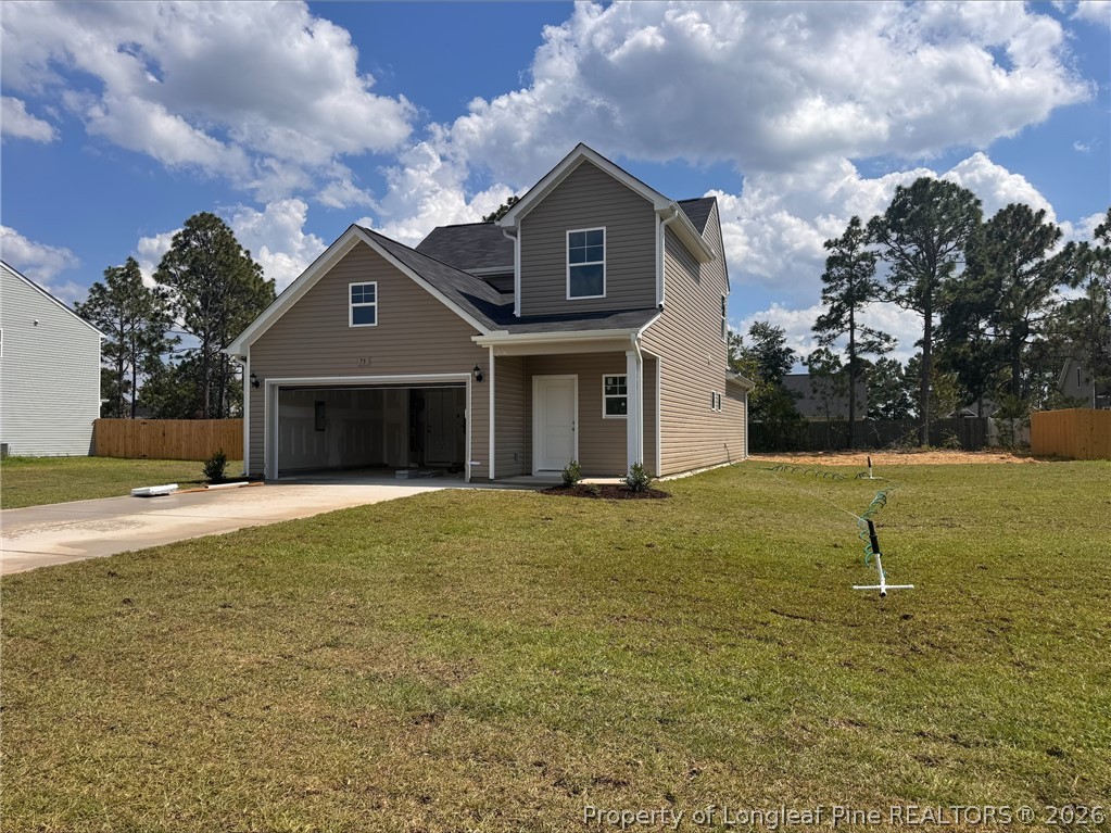 73 Utah Court Spring Lake, NC 28390 - Photo 2 of 4 a front view of a house with a yard and garage