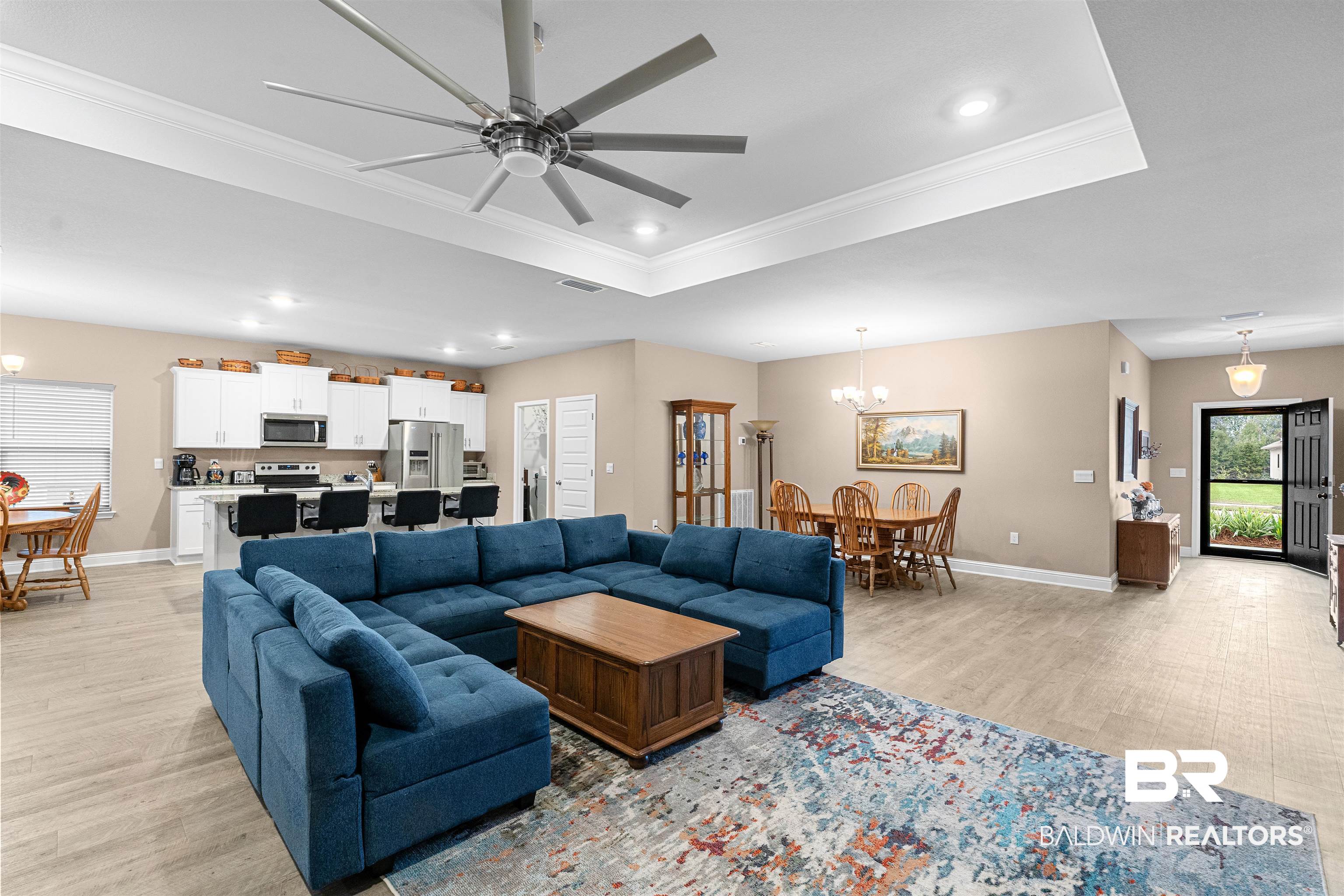 697 Calibre Street Fairhope, AL 36532 - Photo 3 of 18 Living room featuring a chandelier, a ceiling fan, light wood finished floors, and crown molding