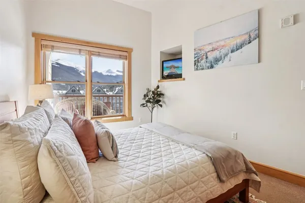 a bedroom with a bed and glass windows