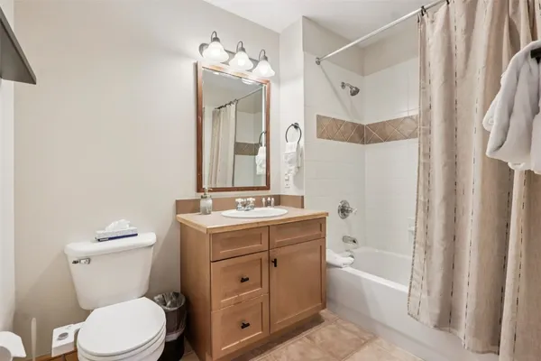 a bathroom with a granite countertop sink toilet mirror and a bathtub