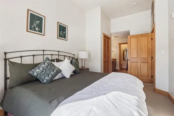 a bedroom with a bed and painting on the wall