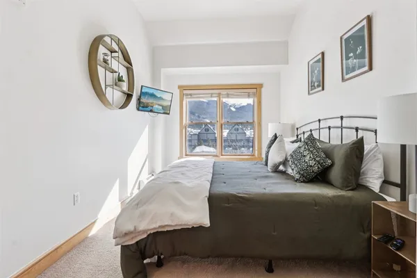 a bedroom with bed and a large window