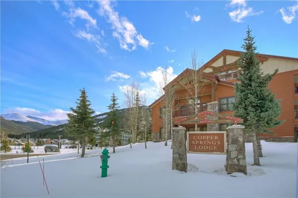 a sign board with buildings in the background