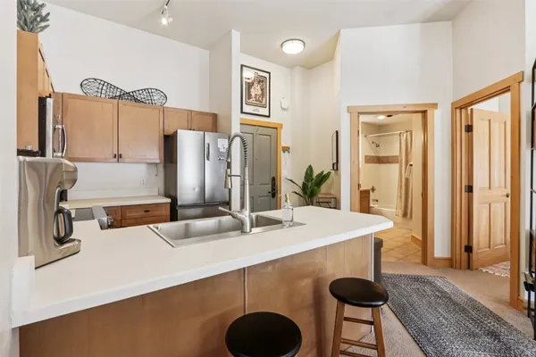 a kitchen with stainless steel appliances granite countertop a sink a stove and a refrigerator