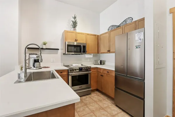 a kitchen with granite countertop a refrigerator stove and sink