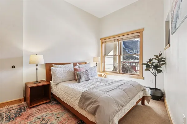 a bedroom with a bed and a potted plant