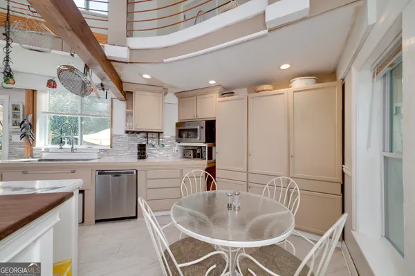 a living room with furniture a flat screen tv and kitchen view