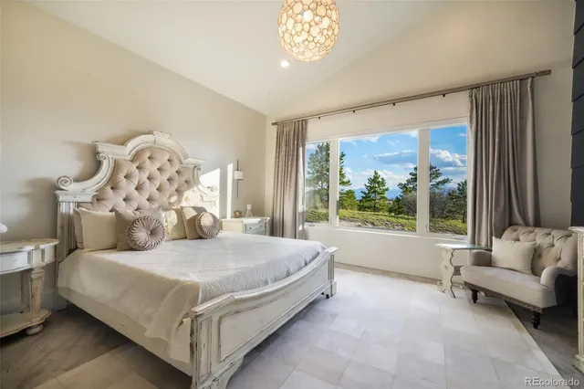 a bed sitting in a spacious bedroom next to a window