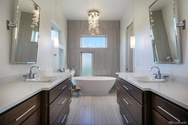 a bathroom with a sink double vanity granite tub and a mirror