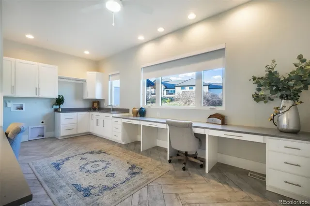 a open kitchen with white cabinets and wooden floor
