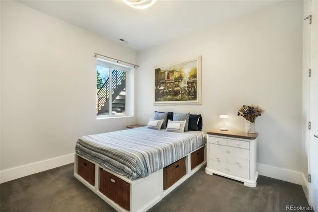 a bedroom with a bed and a painting on the wall