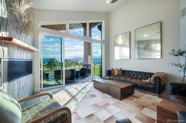 a living room with furniture large window and flat screen tv