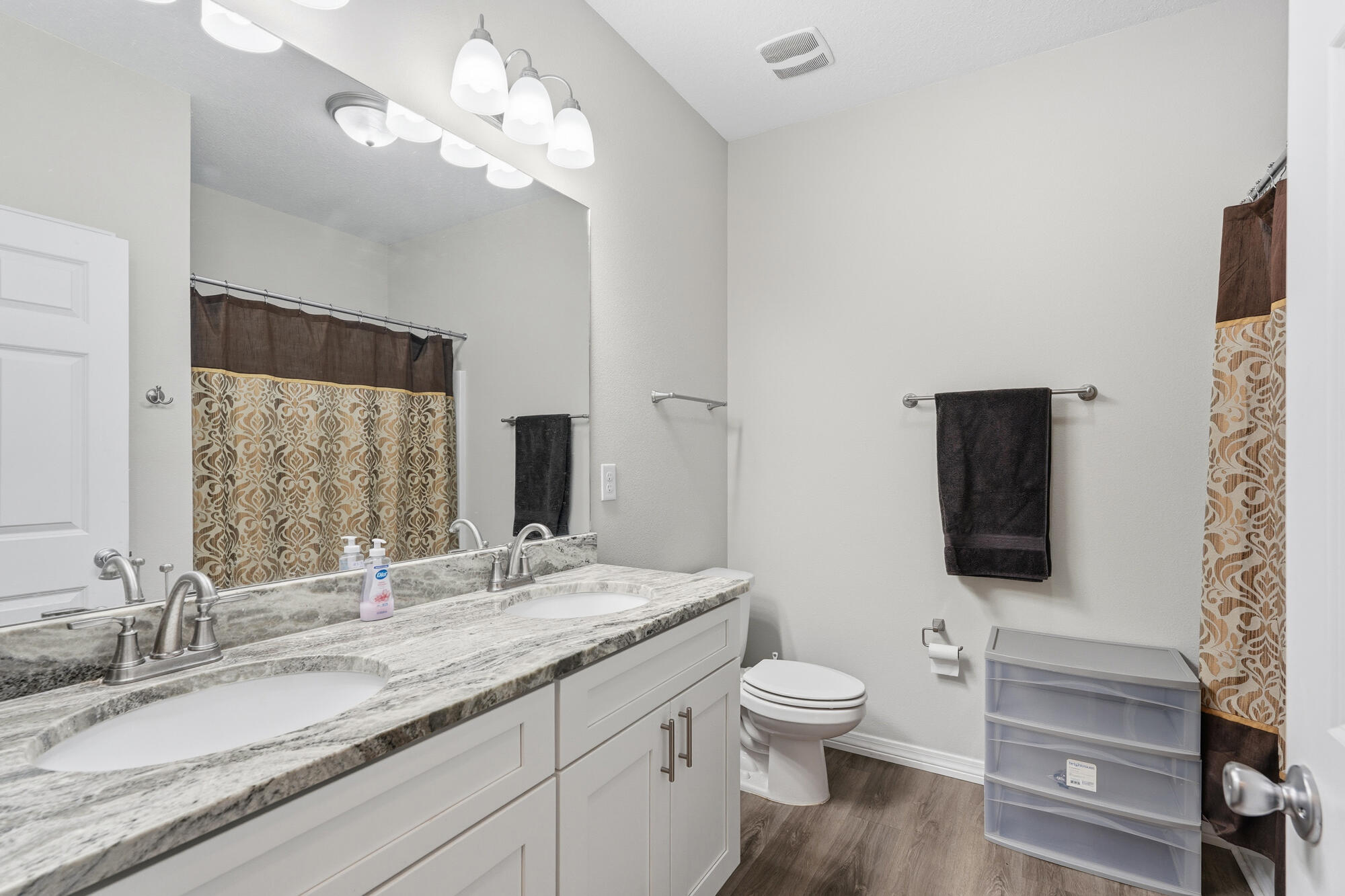 2012 North Pearl Street Crestview, FL 32536 - Photo 14 of 25 a bathroom with a granite countertop toilet a sink and a large mirror