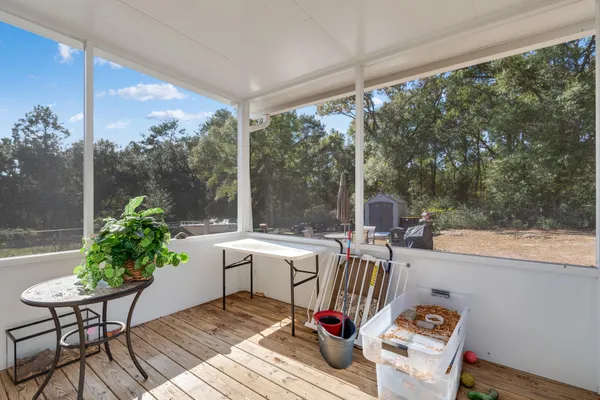 a view of a porch with furniture and a yard
