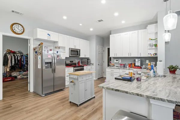 a kitchen that has a lot of cabinets a sink and a stove in it