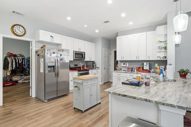 a kitchen that has a lot of cabinets a sink and a stove in it