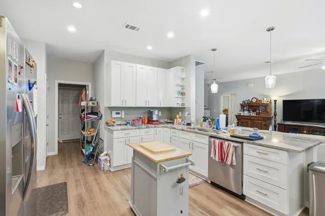 a kitchen with stainless steel appliances granite countertop a refrigerator stove microwave and sink