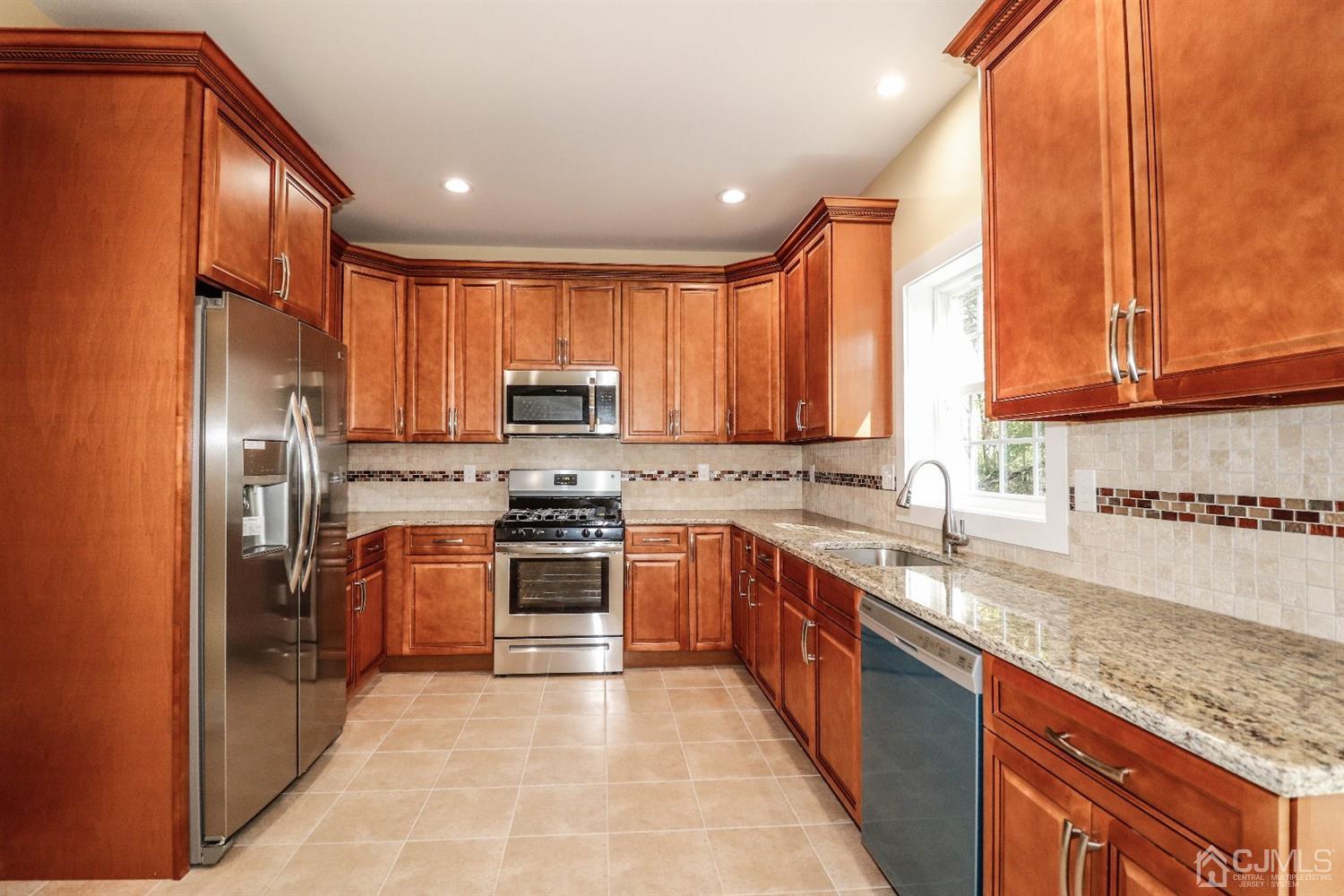 1834 Oak Road North Brunswick, NJ 08902 - Photo 10 of 39 Stunning kitchen with granite counters, tiled backsplash, stainless steel appliances including refrigerator plus recess lighting. Just gorgeous.