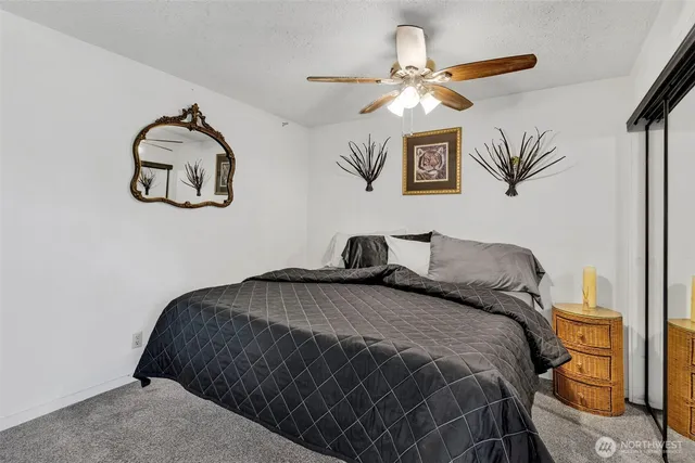 a bedroom with a bed and a lamp on the dresser