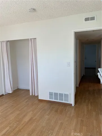 an empty room with wooden floor and closet