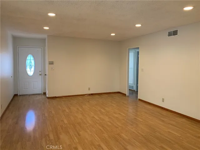 an empty room with wooden floor and mirror