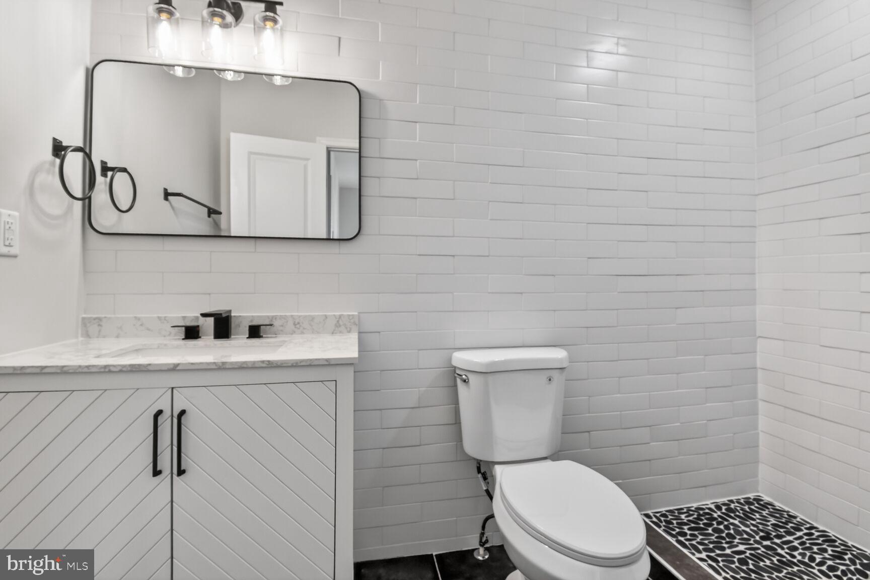 305 Decatur Street Northwest Washington, DC 20011 - Photo 14 of 21 a bathroom with a toilet a sink and mirror