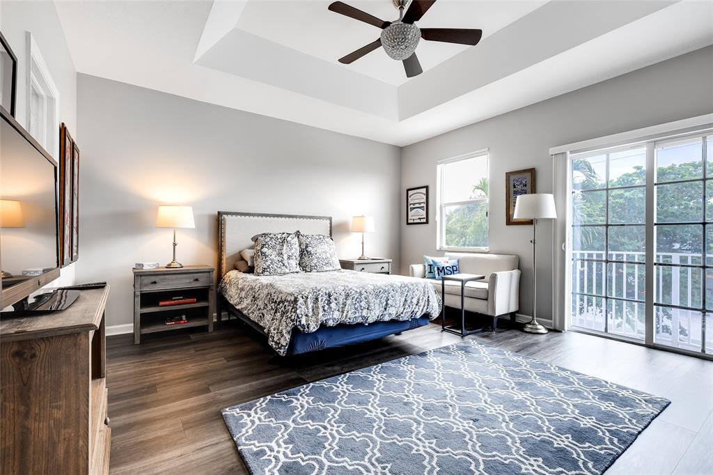 1224 Northeast 18th Avenue, Unit 1 Fort Lauderdale, FL 33304 - Photo 14 of 34 a bedroom with a bed and a dresser with wooden floor
