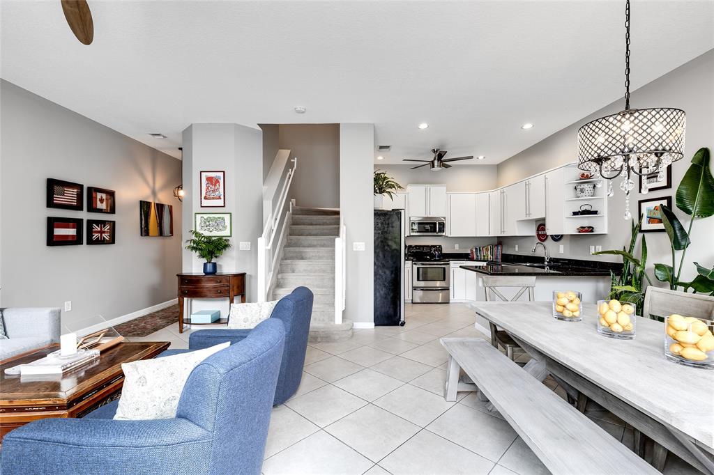 1224 Northeast 18th Avenue, Unit 1 Fort Lauderdale, FL 33304 - Photo 5 of 34 a large kitchen with stainless steel appliances kitchen island granite countertop a refrigerator a stove a sink a dining table and chairs with wooden floor