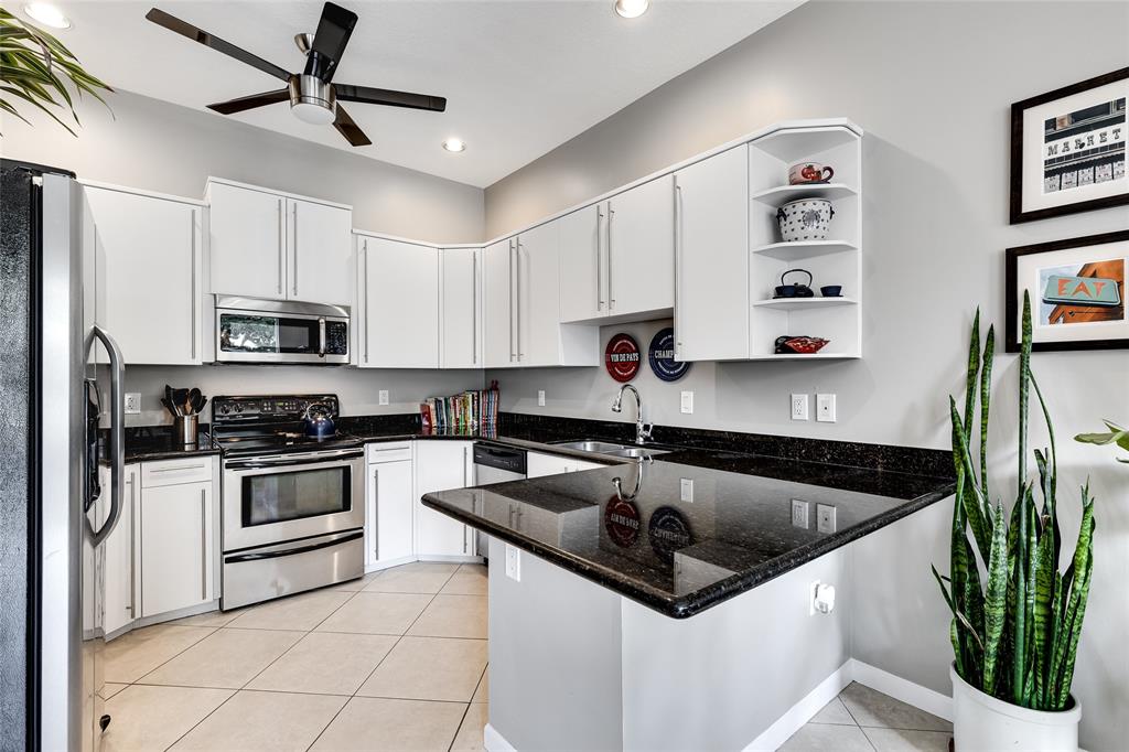 1224 Northeast 18th Avenue, Unit 1 Fort Lauderdale, FL 33304 - Photo 10 of 34 a kitchen with granite countertop a sink stainless steel appliances and white cabinets