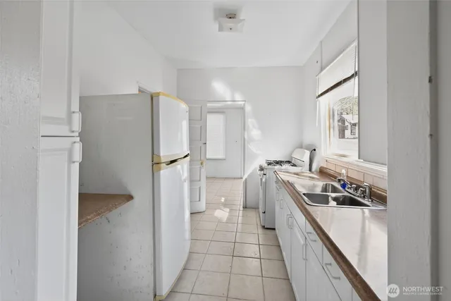 a kitchen with a refrigerator a stove top oven and cabinets