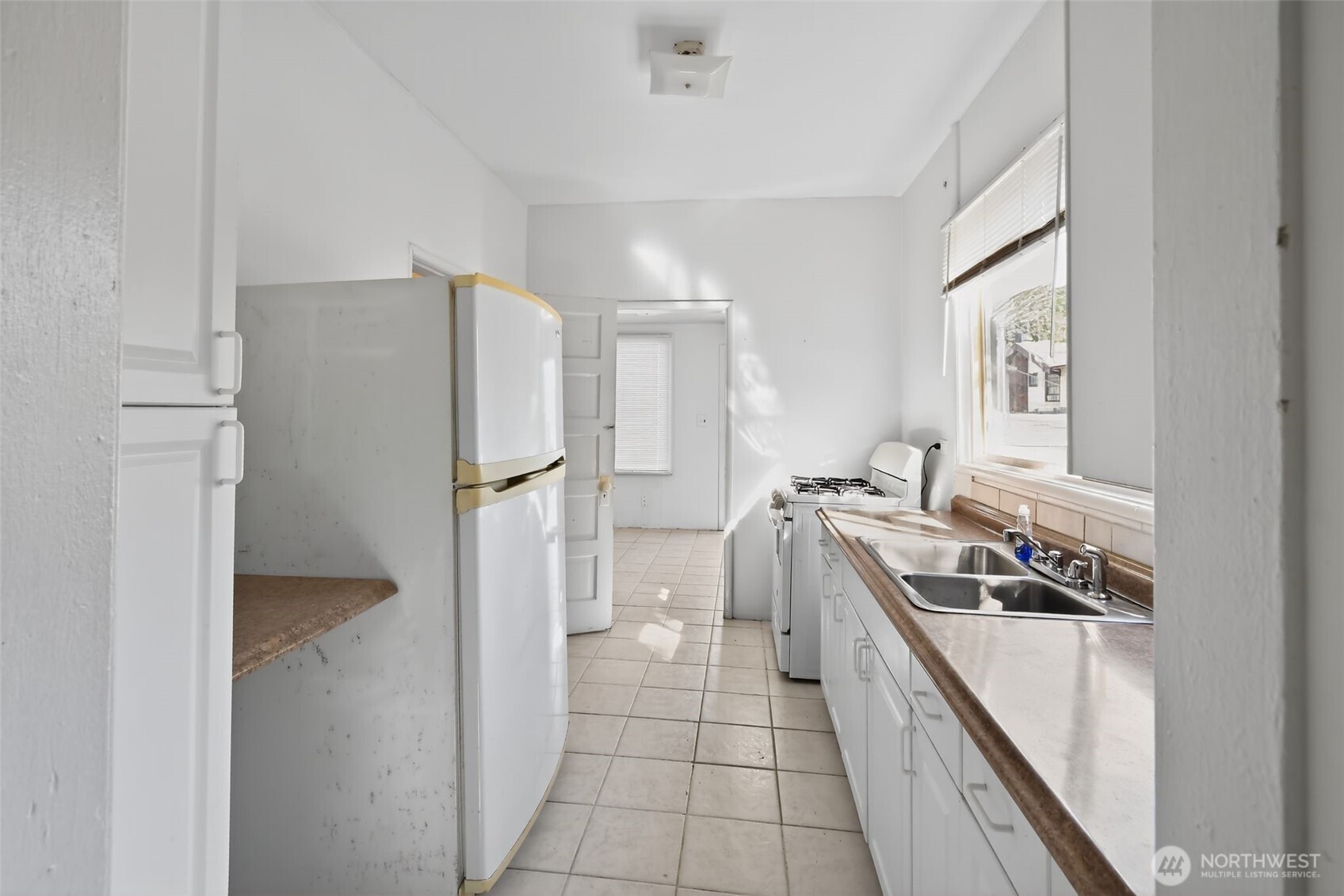 208 North M Street Aberdeen, WA 98520 - Photo 7 of 18 a kitchen with a refrigerator a stove top oven and cabinets