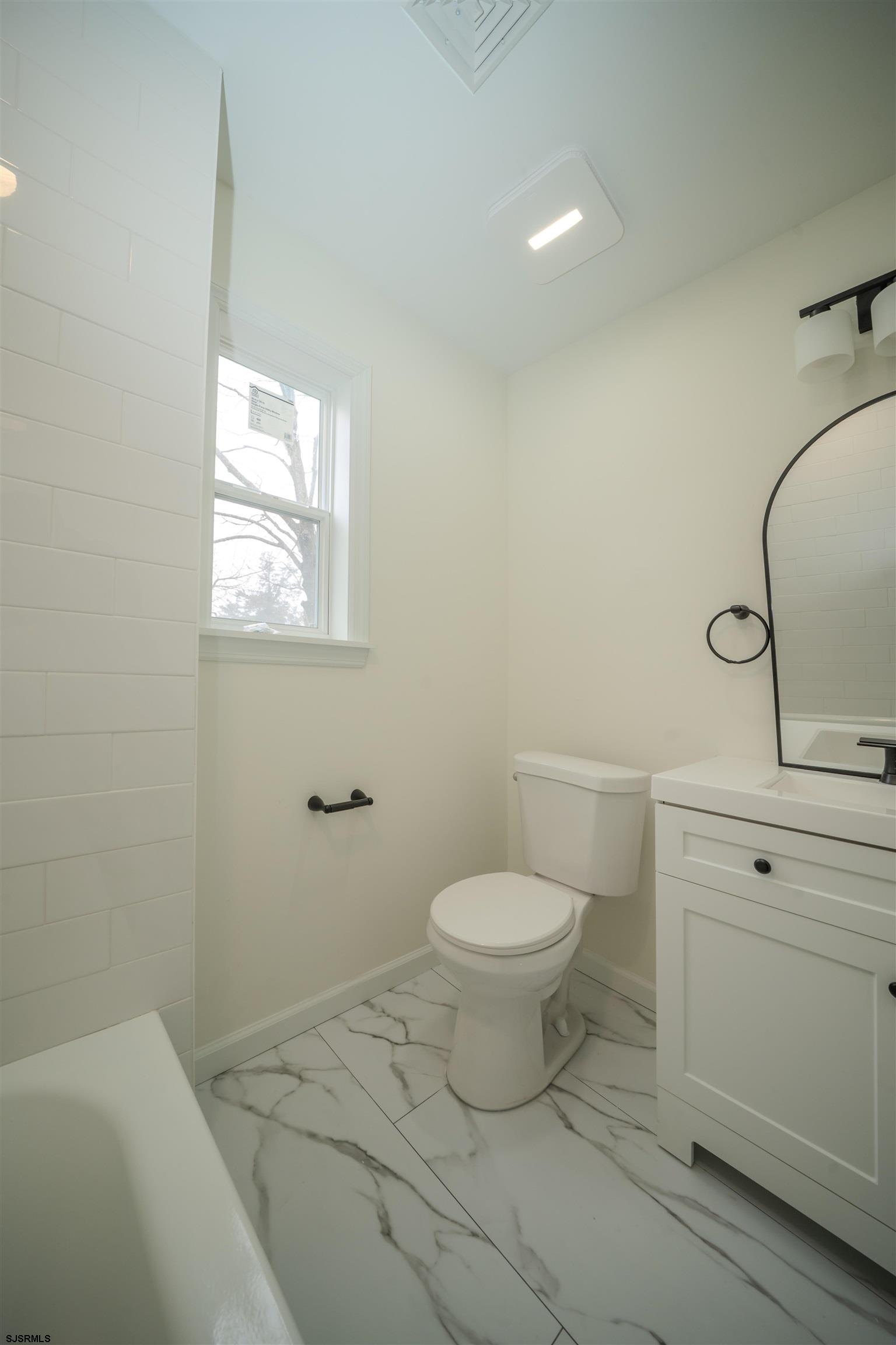 115 Ryon Avenue Pleasantville, NJ 08232 - Photo 11 of 12 a bathroom with a toilet a sink and mirror
