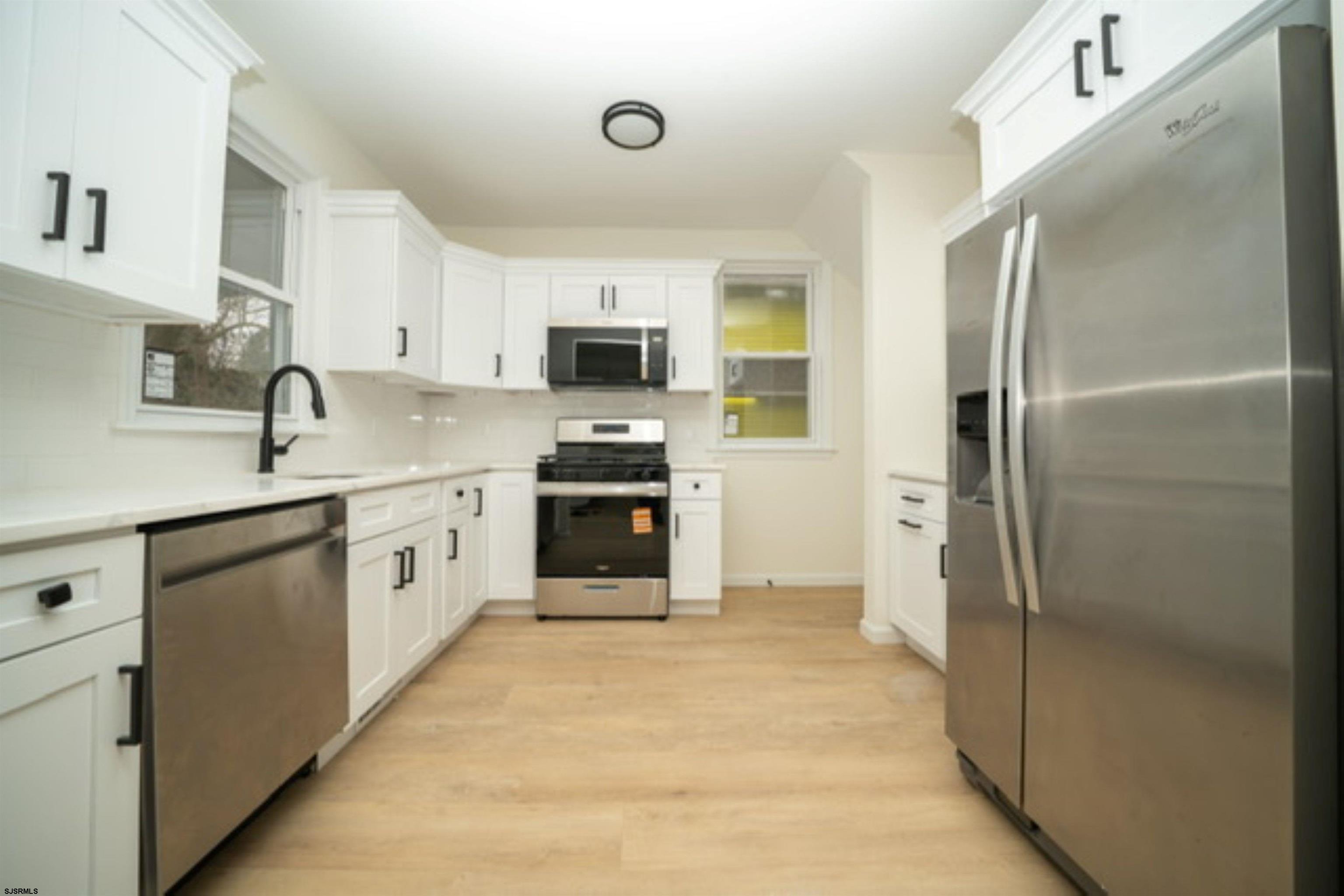 115 Ryon Avenue Pleasantville, NJ 08232 - Photo 4 of 12 a kitchen with stainless steel appliances granite countertop a refrigerator sink and stove