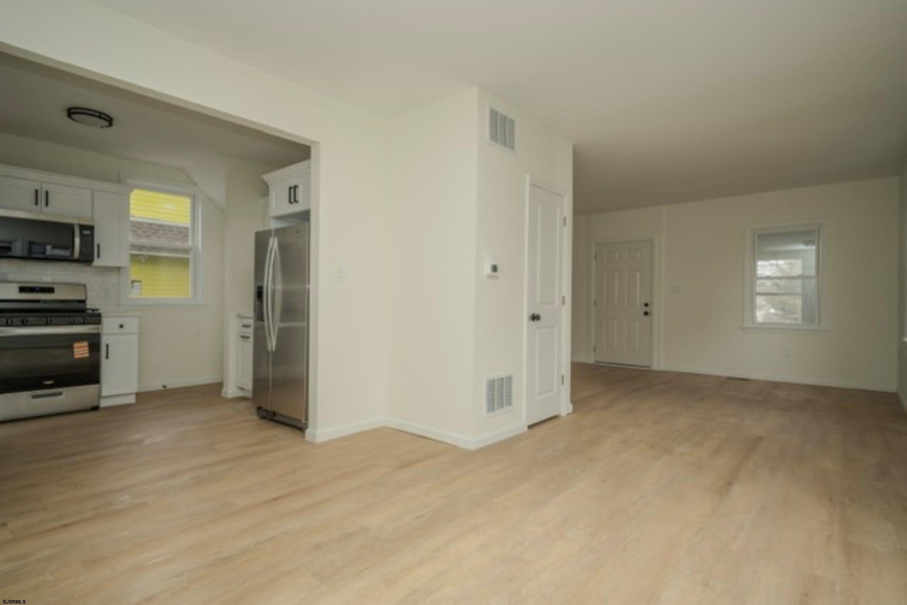 115 Ryon Avenue Pleasantville, NJ 08232 - Photo 9 of 12 a view of a kitchen with a stove cabinets and a wooden floor