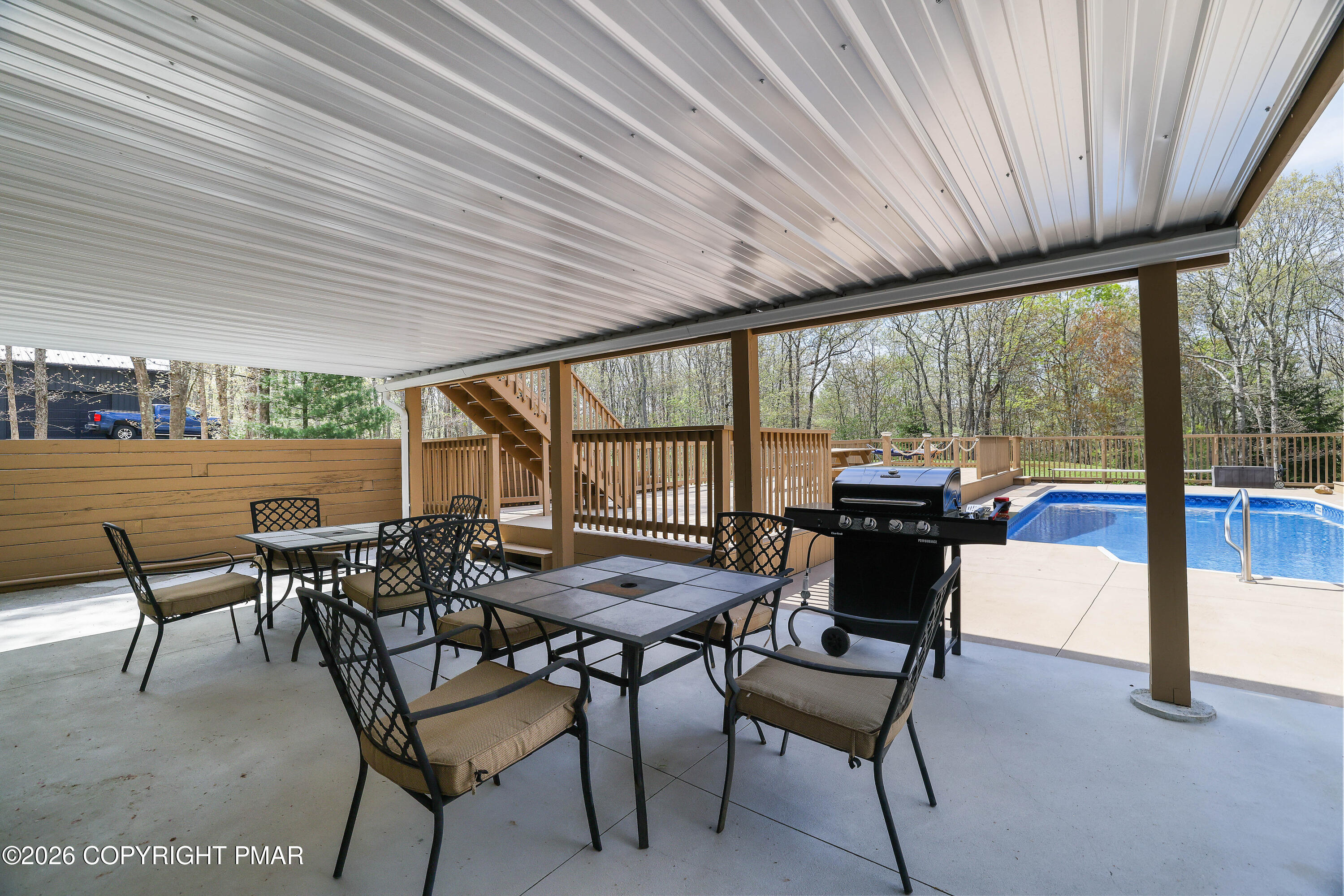 659 Behrens Road Jim Thorpe, PA 18229 - Photo 44 of 57 a view of a patio with a table and chairs and couches with wooden roof and stairs
