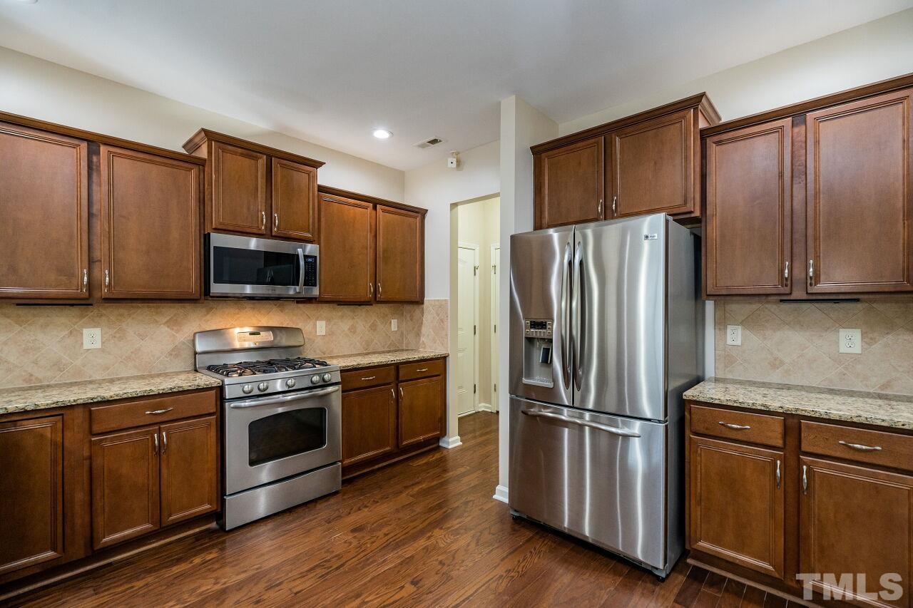 4713 Gaelic Trail Raleigh, NC 27604 - Photo 12 of 26 a kitchen with stainless steel appliances granite countertop a refrigerator stove and microwave