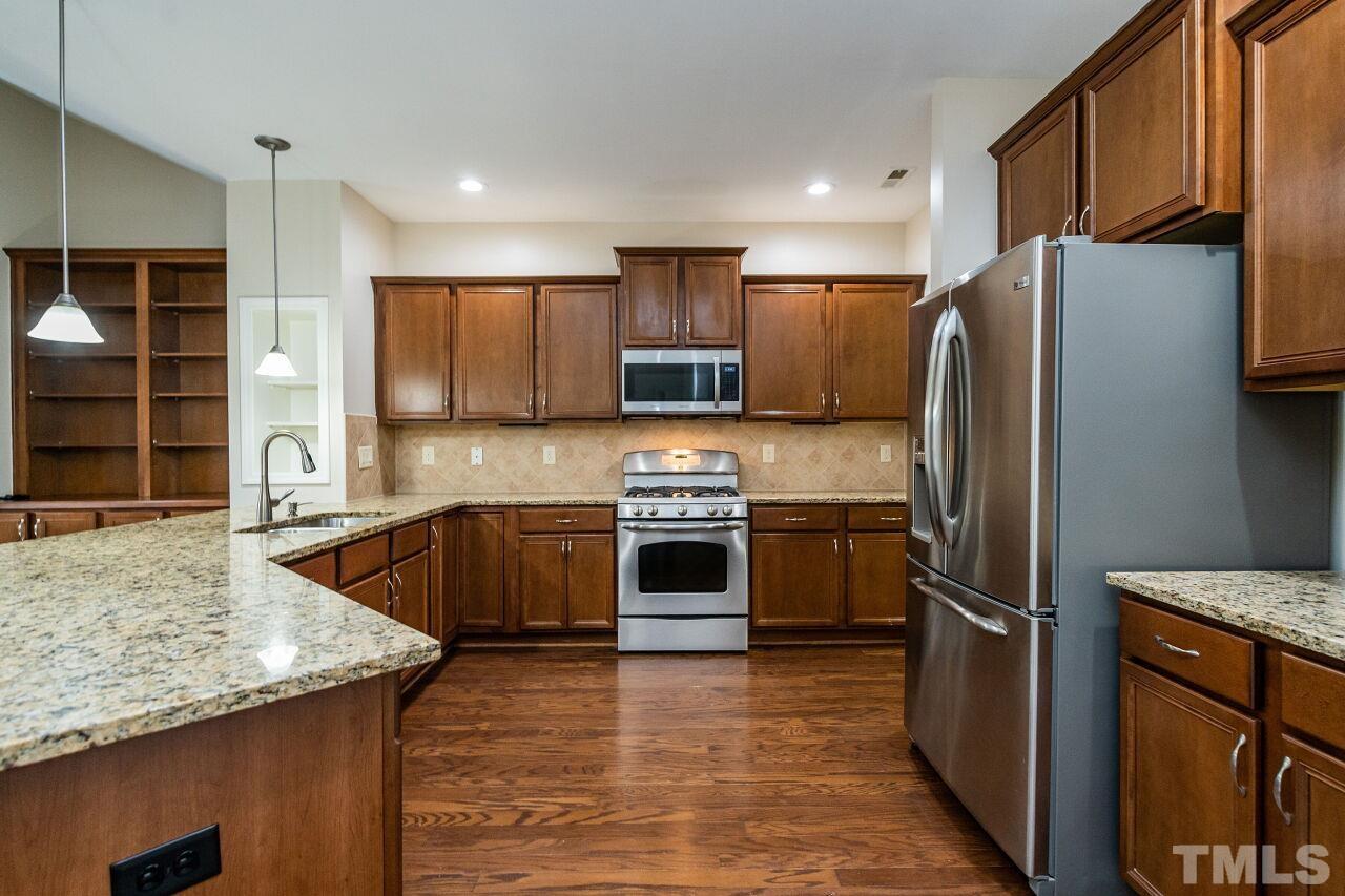 4713 Gaelic Trail Raleigh, NC 27604 - Photo 13 of 26 a kitchen with stainless steel appliances granite countertop a refrigerator a stove and a sink