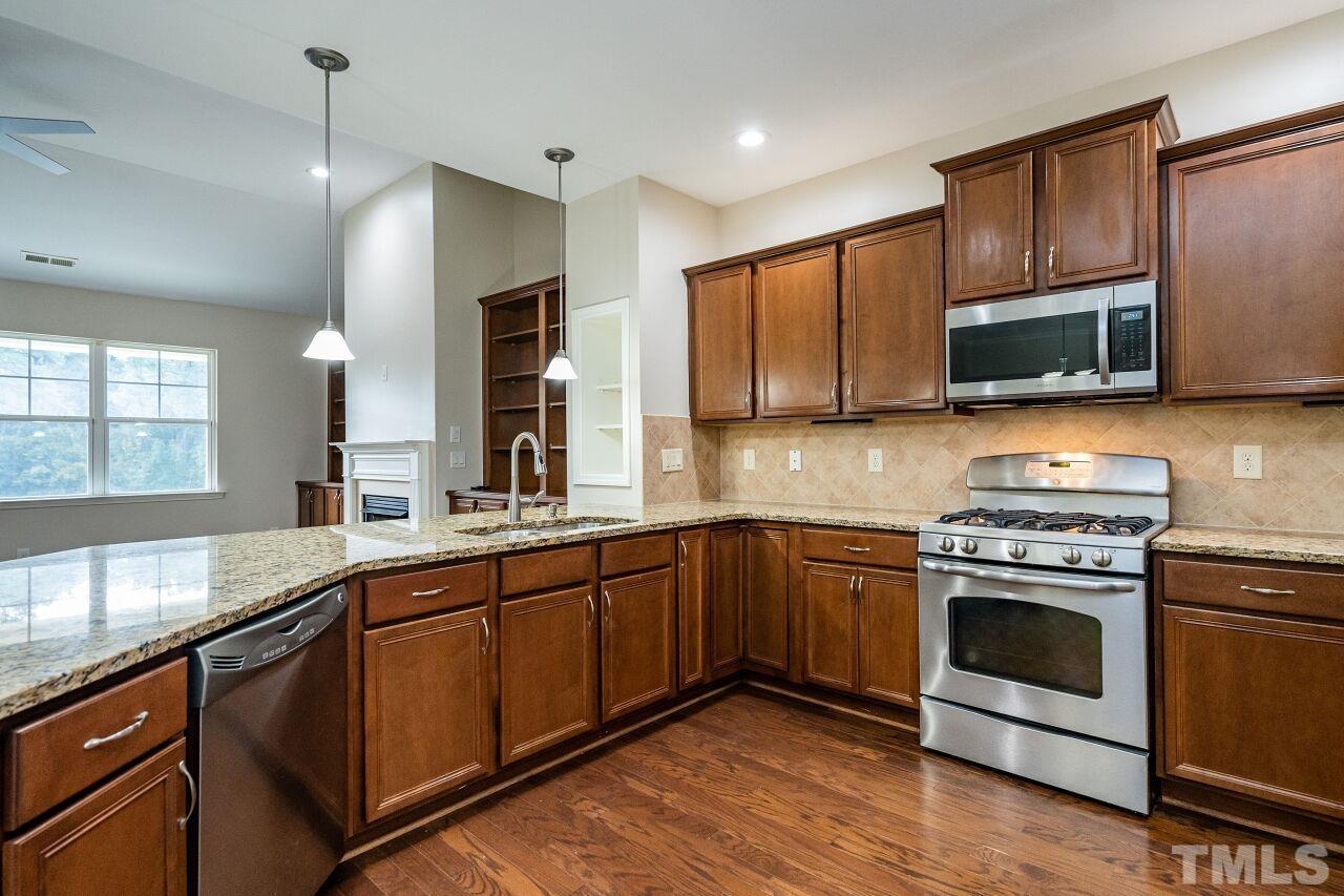 4713 Gaelic Trail Raleigh, NC 27604 - Photo 14 of 26 a kitchen with stainless steel appliances granite countertop wooden cabinets granite counter tops and a stove