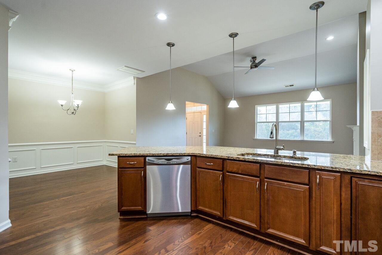 4713 Gaelic Trail Raleigh, NC 27604 - Photo 15 of 26 a kitchen with stainless steel appliances granite countertop a sink a stove and a wooden floors