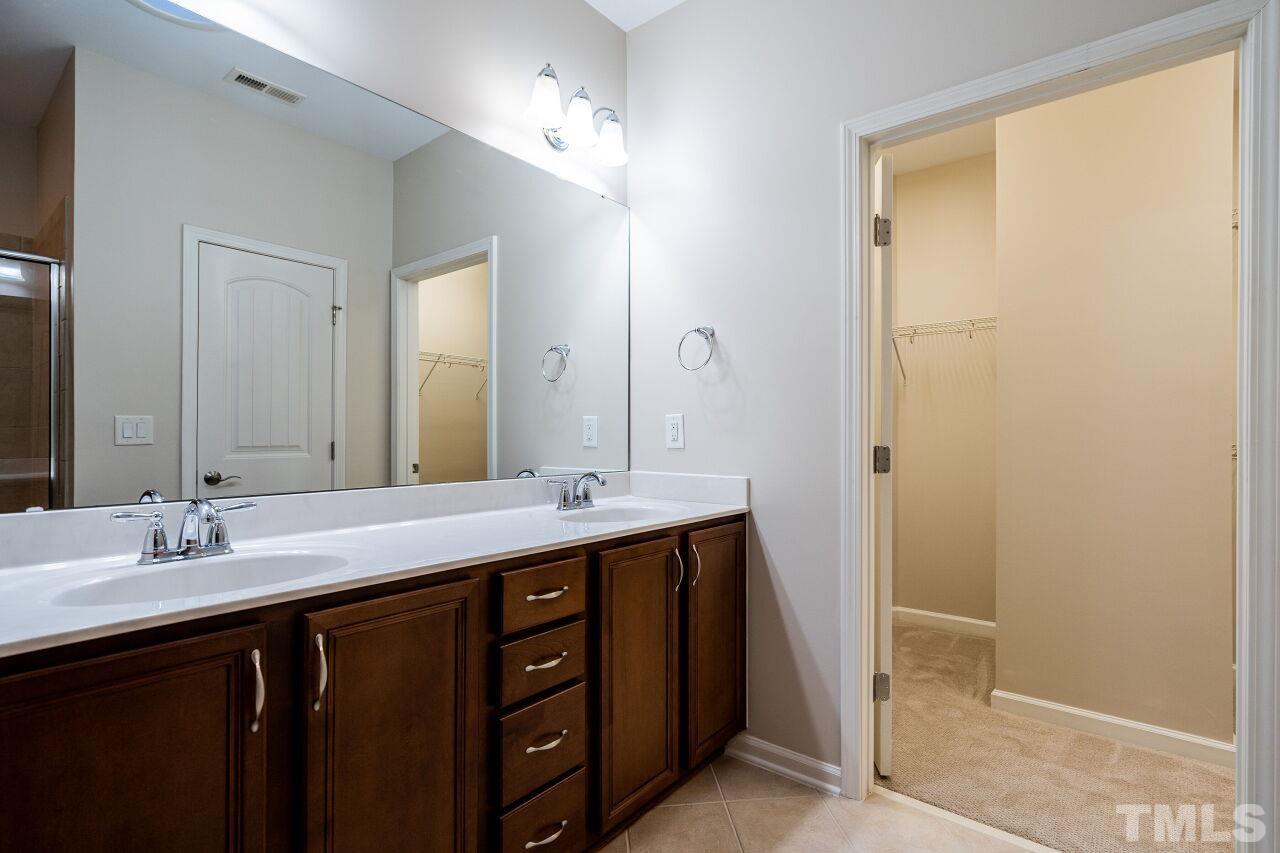 4713 Gaelic Trail Raleigh, NC 27604 - Photo 19 of 26 a bathroom with a double vanity sink and mirror