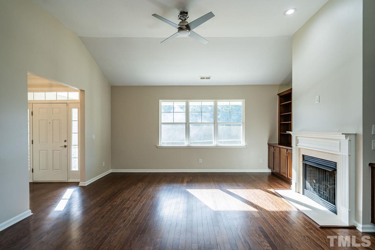4713 Gaelic Trail Raleigh, NC 27604 - Photo 8 of 26 an empty room with wooden floor a ceiling fan and windows